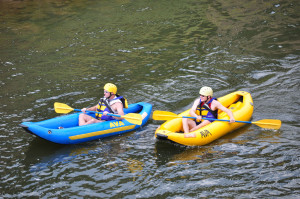 People in inflatable kayaks in river