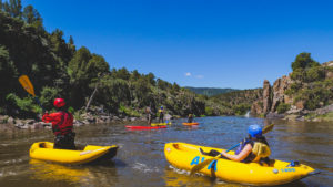 yellow inflatable kayaks on the Colorado River with a bright blue sky